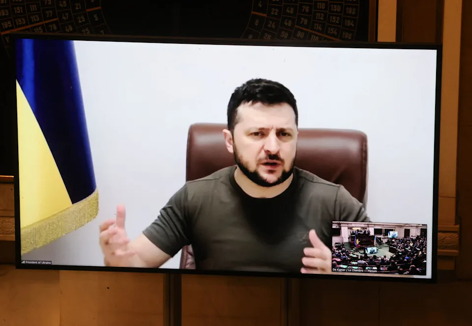 Ukrainian President Volodymyr Zelensky is seen onscreen during a video feed to the Belgian Parliament. 