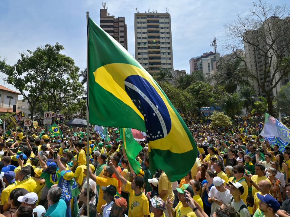 Supporters of Brazil's President Jair Bolsonaro wave a Brazilian flag during a campaign rally.